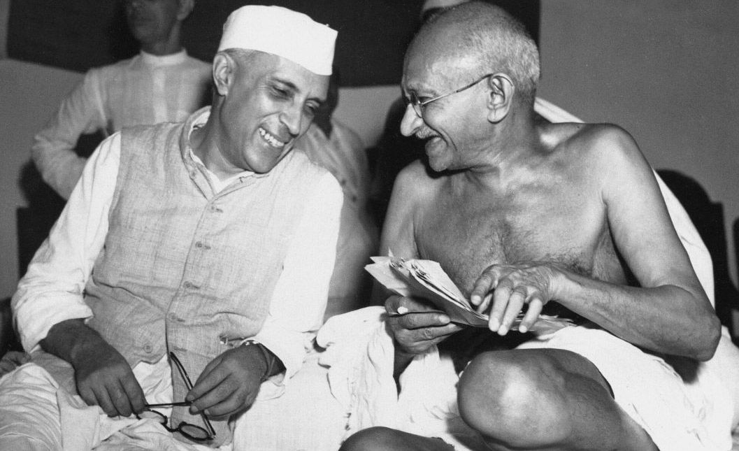 Jawaharlal Nehru sharing a joke with Mahatma Gandhi, during a meeting of the All India Congress, Mumbai, July 6, 1946. Public Domain.